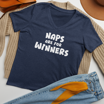 "Naps Are For Winners" printed on a heather navy women's relaxed v-neck t-shirt laying on a flat surface amongst other clothes