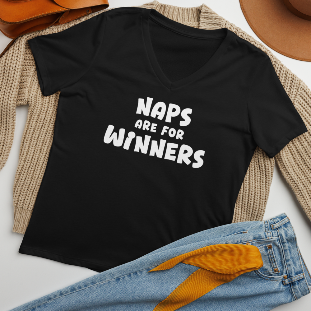 "Naps Are For Winners" printed on a solid black blend women's relaxed v-neck t-shirt laying on a flat surface amongst other clothes
