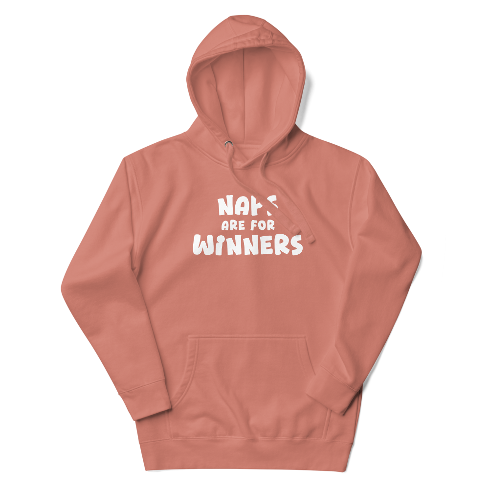 "Naps Are For Winners" printed on a dusty rose unisex hoodie laying on a flat surface with the hood up