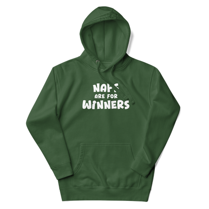 "Naps Are For Winners" printed on a forest green unisex hoodie laying on a flat surface with the hood up