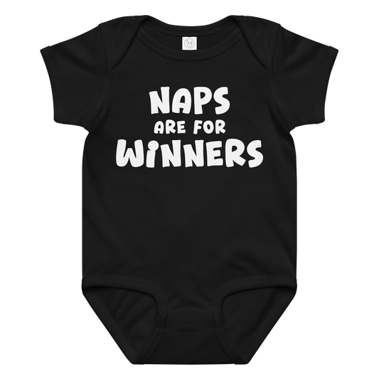 "Naps Are For Winners" printed on a black baby jersey bodysuit laying on a flat surface amongst other clothes