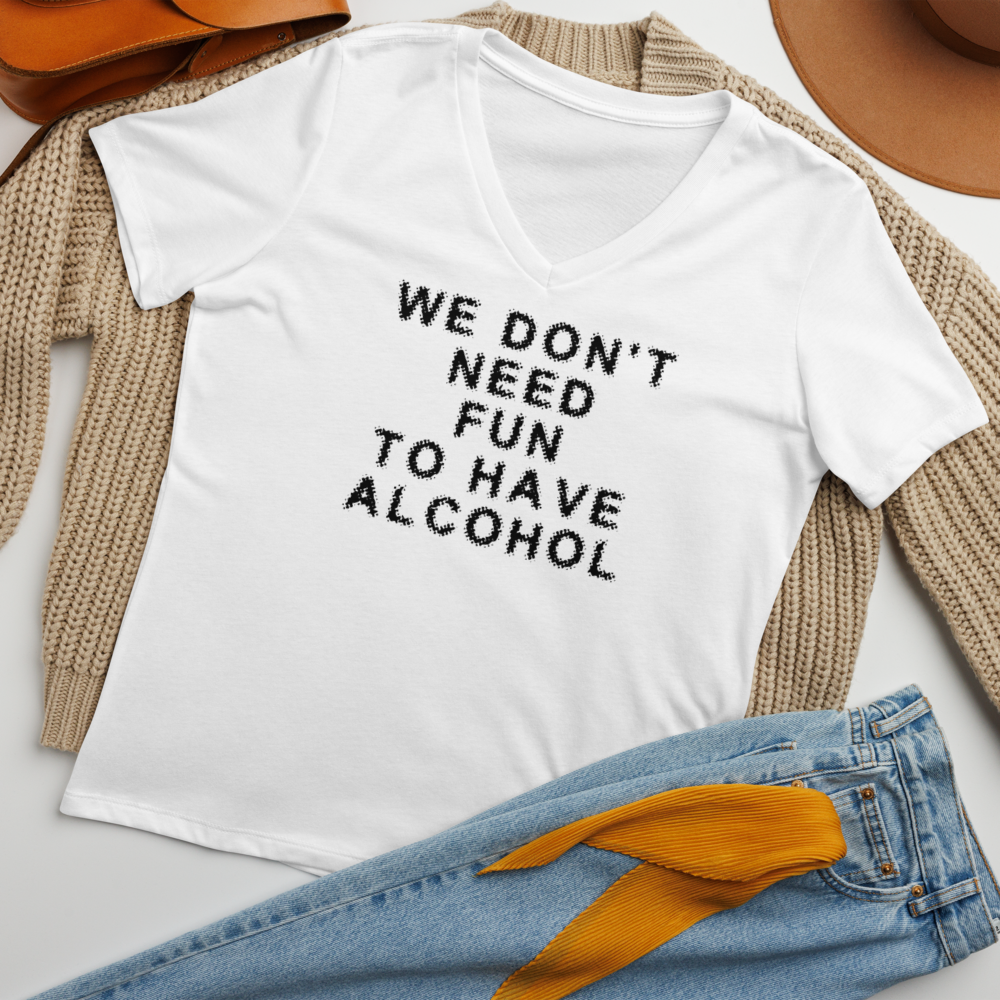 "We don’t need fun to have alcohol" printed on a solid white blend women's relaxed v-neck t-shirt laying on a flat surface amongst other clothes