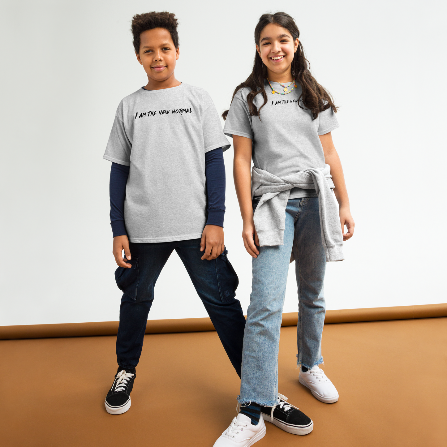 "I am the new normal" printed on a sport grey youth classic tee worn by a female and male