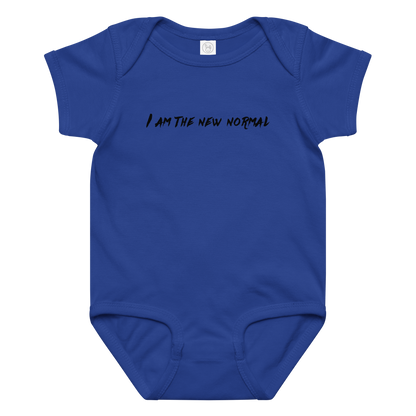 "I am the new normal" printed on a royal baby jersey bodysuit laying on a flat surface amongst other clothes