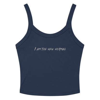 "I am the new normal" printed on a solid navy blend women's micro-rib tanktop laying on a flat surface amongst sunglasses and shorts