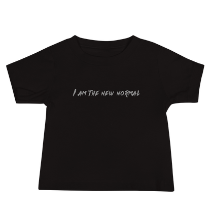 "I am the new normal" printed on a black baby jersey short sleeve tee laying on a flat surface
