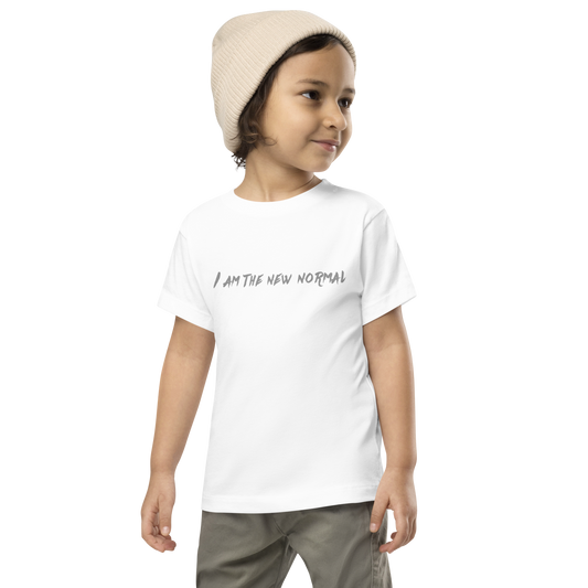"I am the new normal" printed on a white toddler short sleeve tee worn by a male wearing a cap