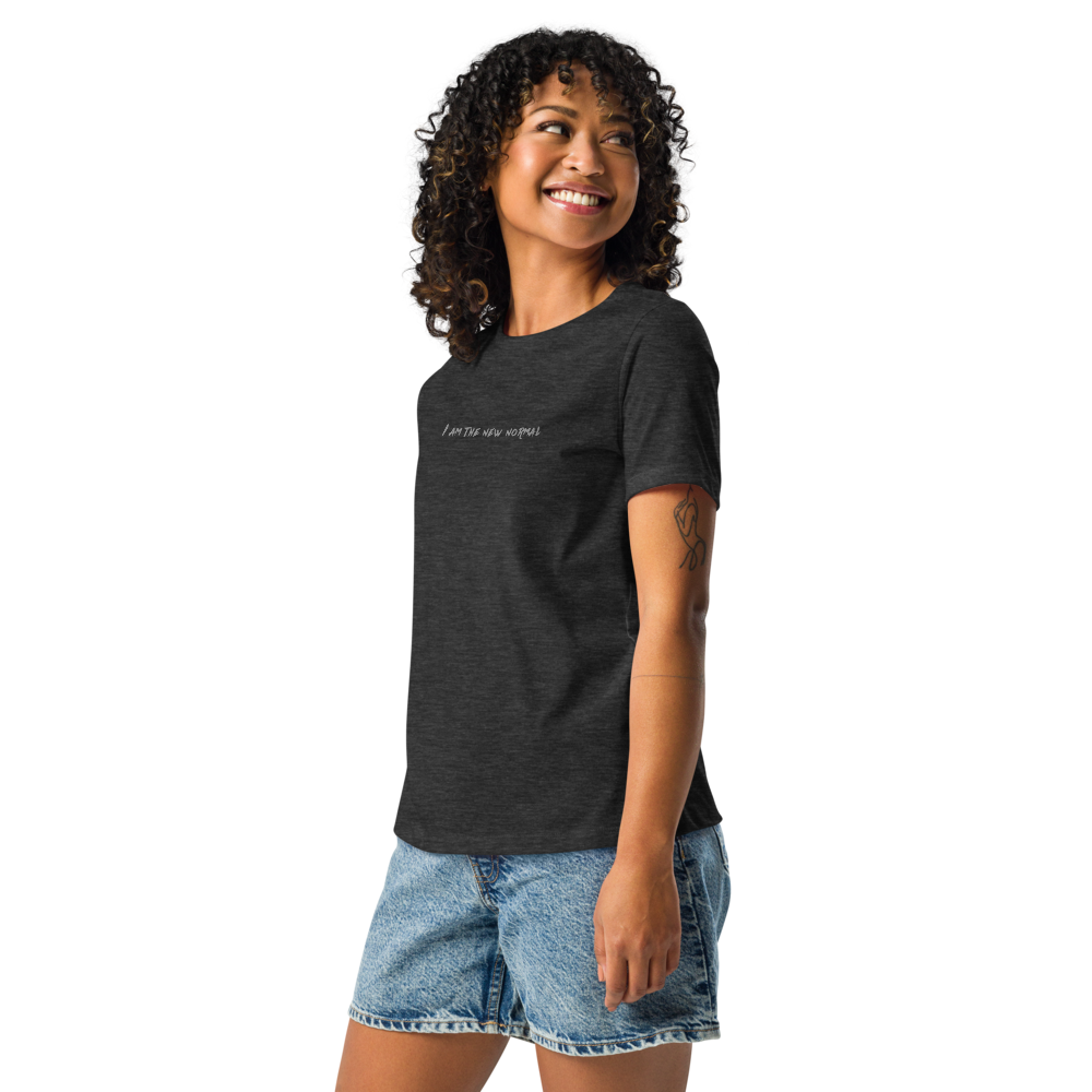 "I am the new normal" printed on a dark grey heather women's relaxed t-shirt worn by a female