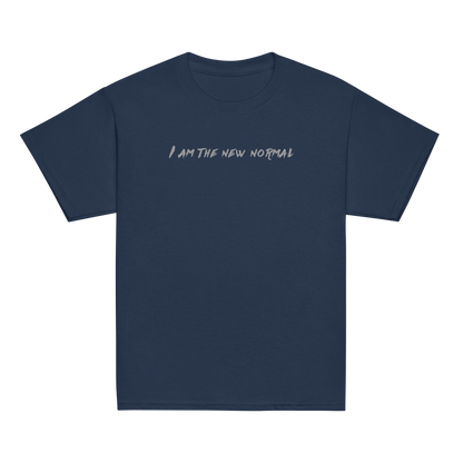 "I am the new normal" printed on a navy youth classic tee laying on a flat surface