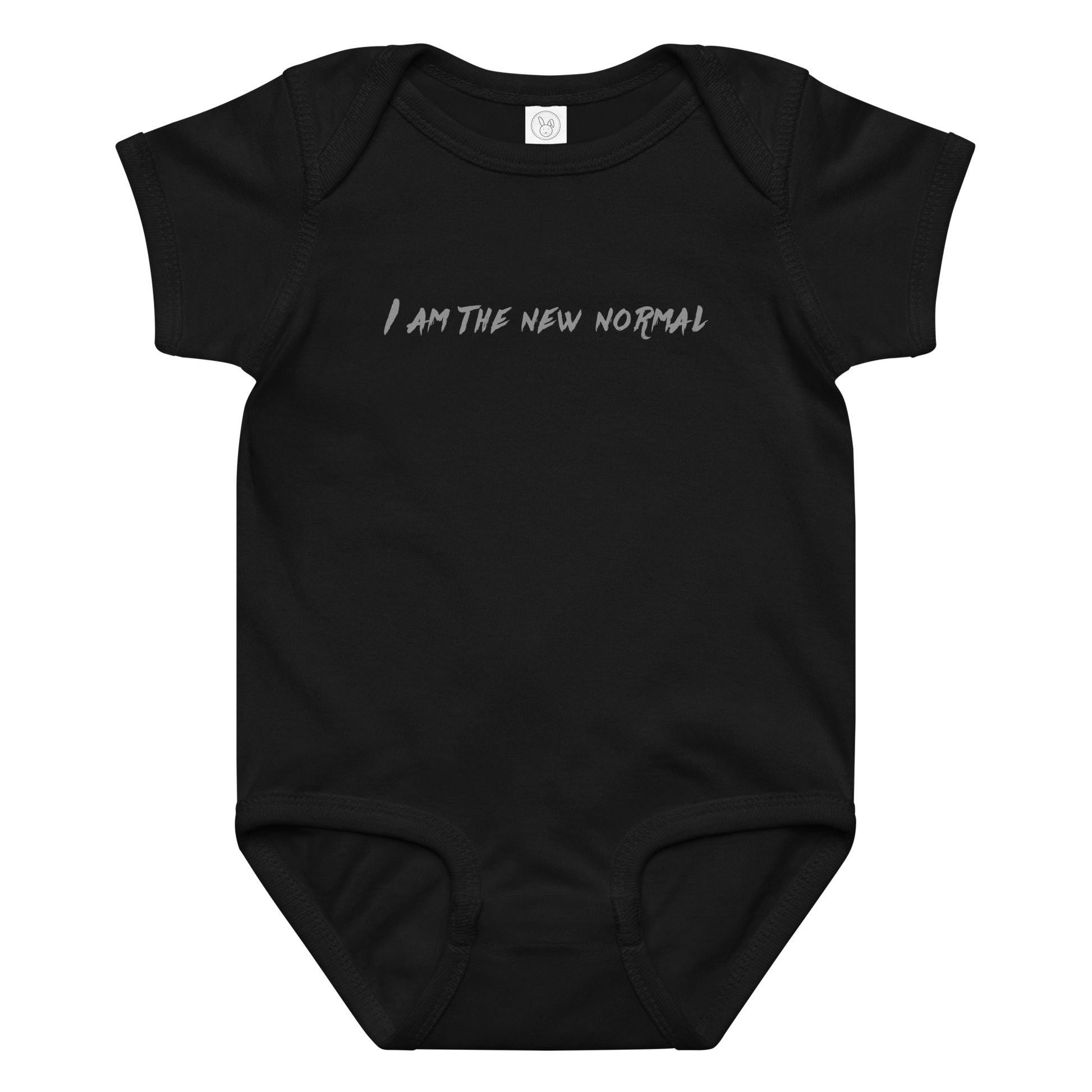 "I am the new normal" printed on a black baby jersey bodysuit laying on a flat surface amongst other clothes