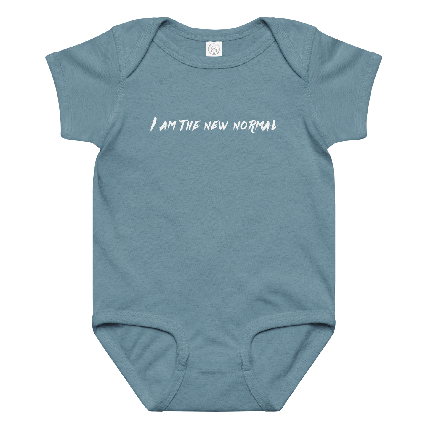 "I am the new normal" printed on a vintage indigo baby jersey bodysuit laying on a flat surface amongst other clothes
