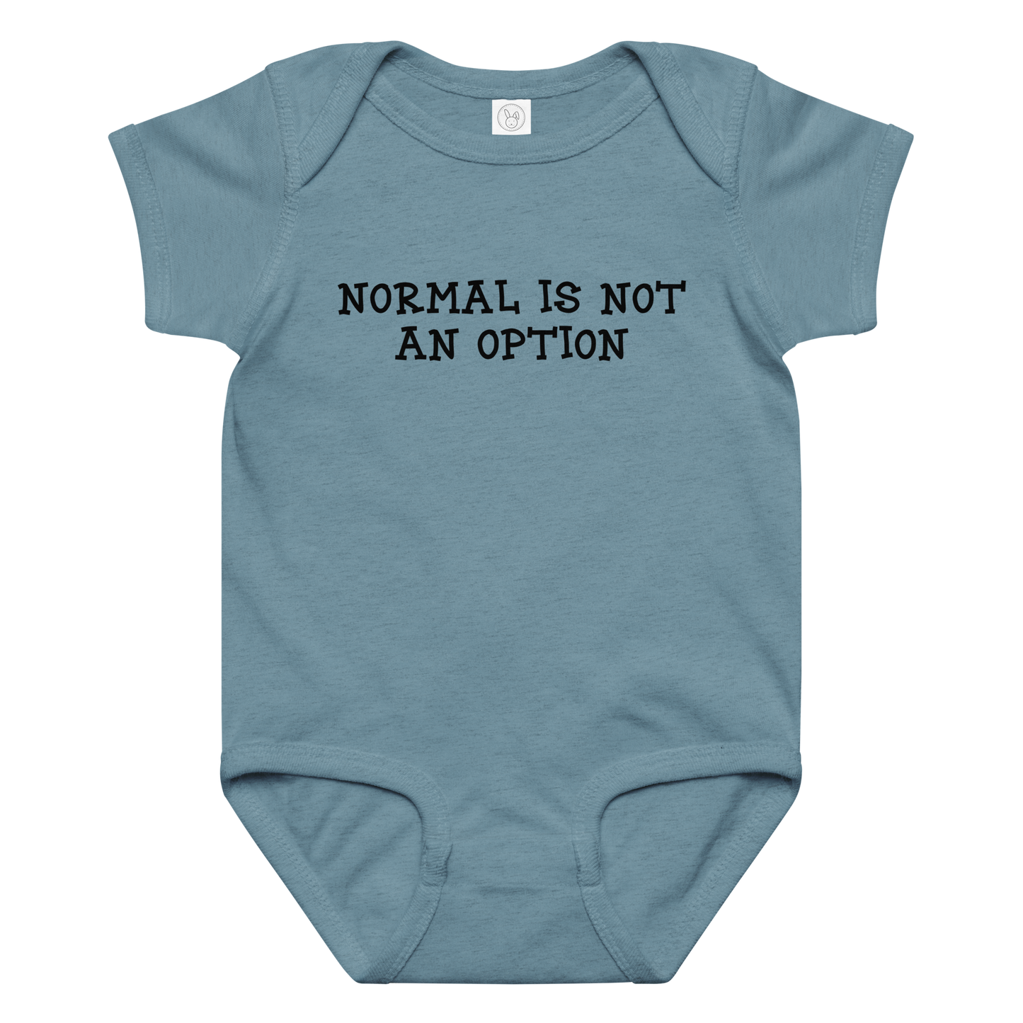 "Normal is not an option" printed on a vintage indigo baby jersey bodysuit laying on a flat surface amongst other clothes
