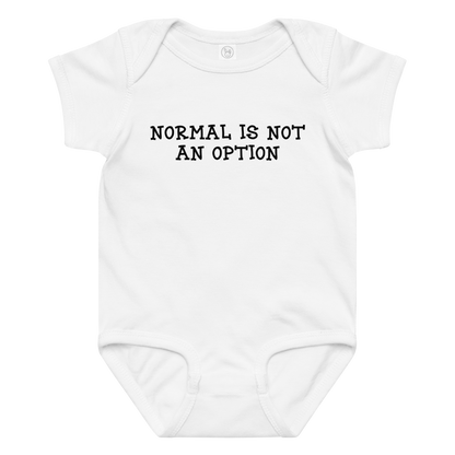 "Normal is not an option" printed on a white baby jersey bodysuit laying on a flat surface amongst other clothes