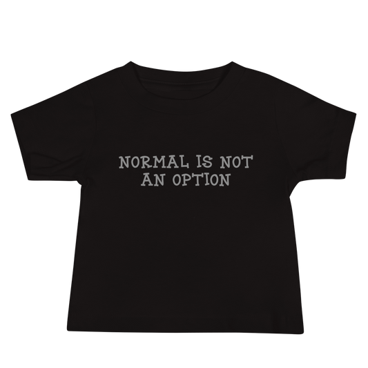 "Normal is not an option" printed on a black baby jersey short sleeve tee laying on a flat surface