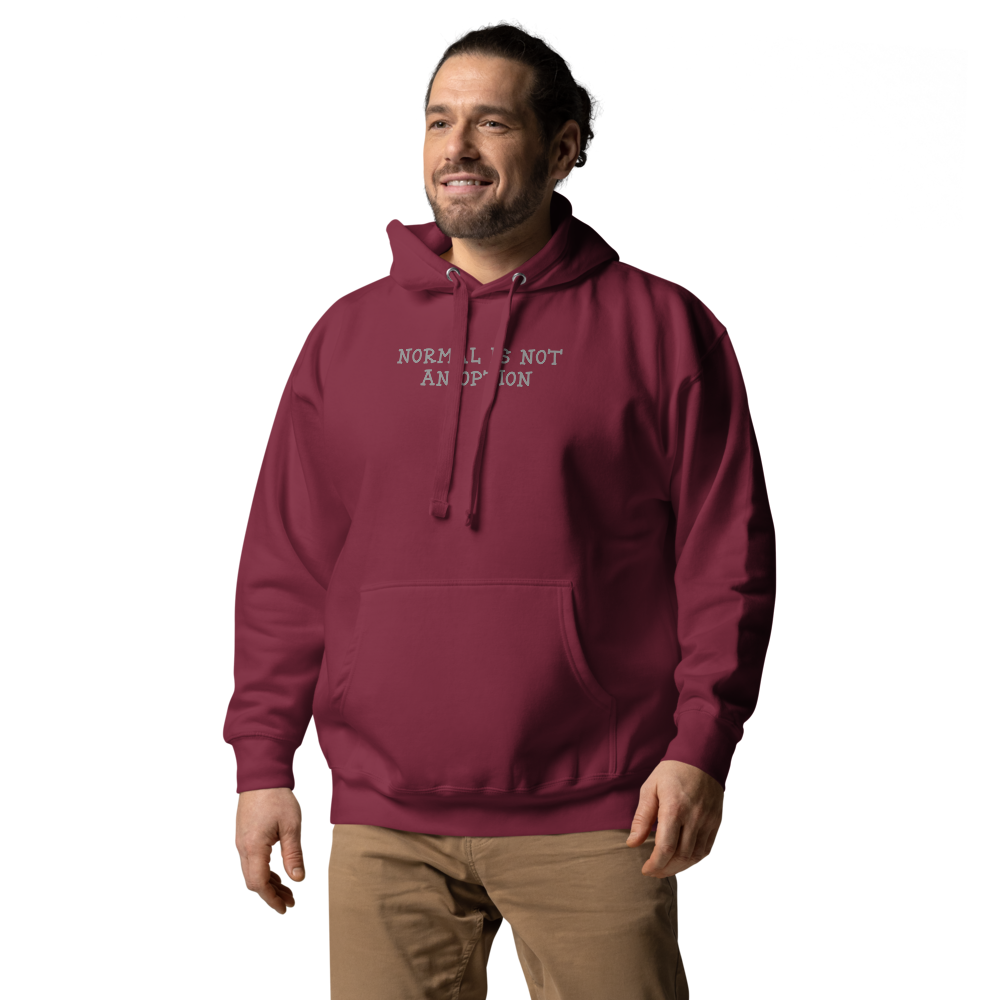 "Normal is not an option" printed on a maroon unisex hoodie worn by a male