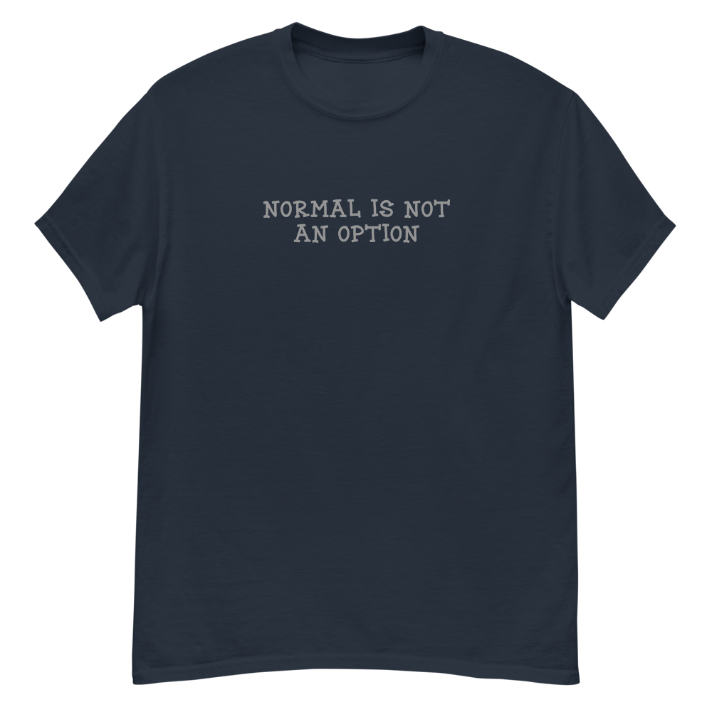 "Normal is not an option" printed on a navy unisex classic tee laying on a flat surface