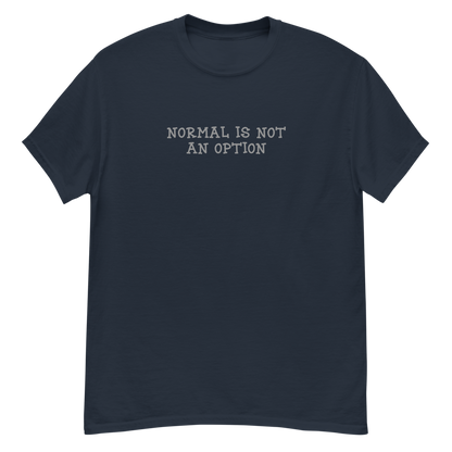 "Normal is not an option" printed on a navy unisex classic tee laying on a flat surface