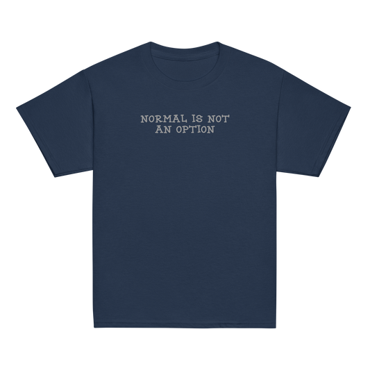 "Normal is not an option" printed on a navy youth classic tee laying on a flat surface