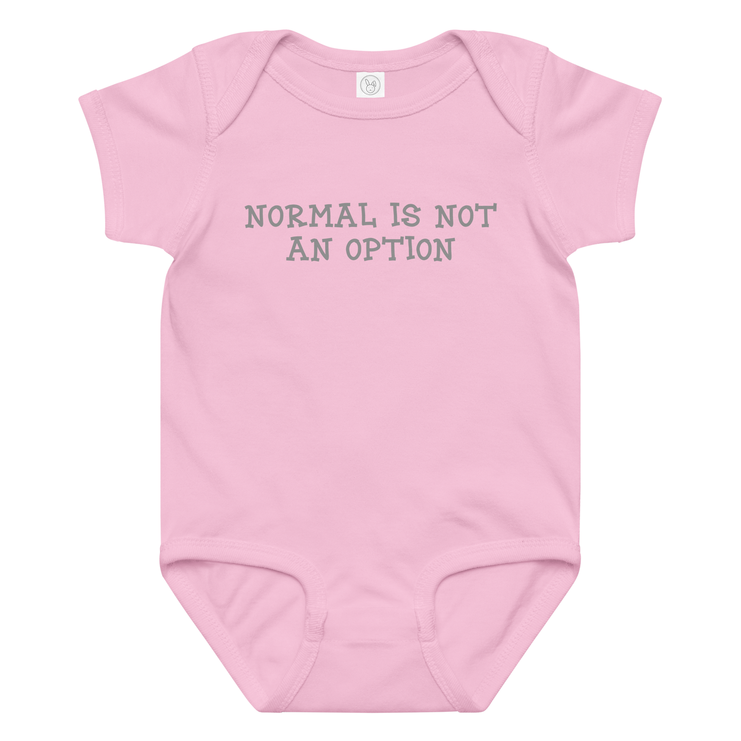 "Normal is not an option" printed on a pink baby jersey bodysuit laying on a flat surface amongst other clothes