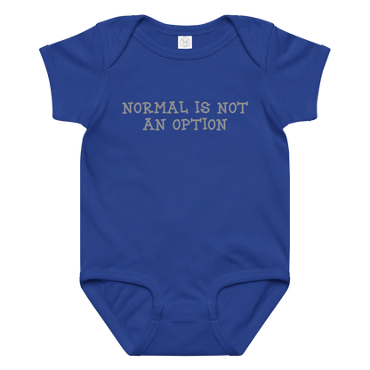 "Normal is not an option" printed on a royal baby jersey bodysuit laying on a flat surface amongst other clothes
