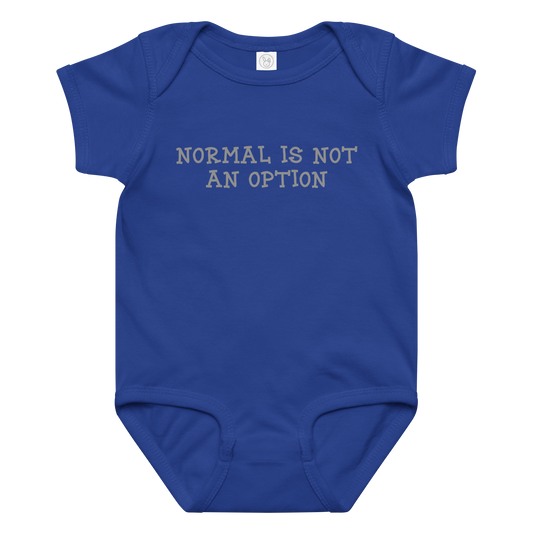"Normal is not an option" printed on a royal baby jersey bodysuit laying on a flat surface amongst other clothes