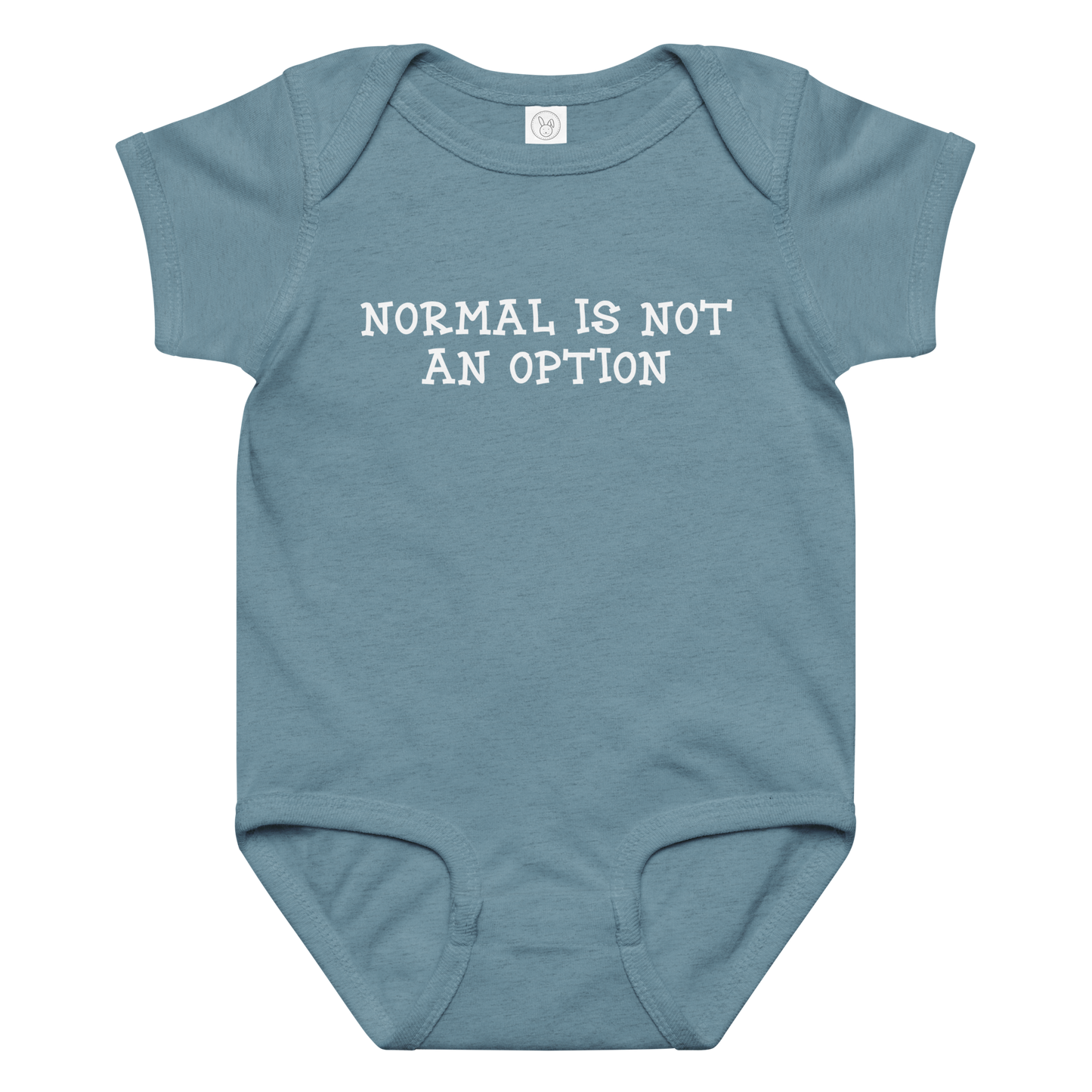 "Normal is not an option" printed on a vintage indigo baby jersey bodysuit laying on a flat surface amongst other clothes