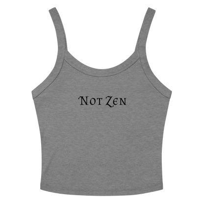 "Not zen" printed on a athletic heather women's micro-rib tanktop laying on a flat surface amongst sunglasses and shorts