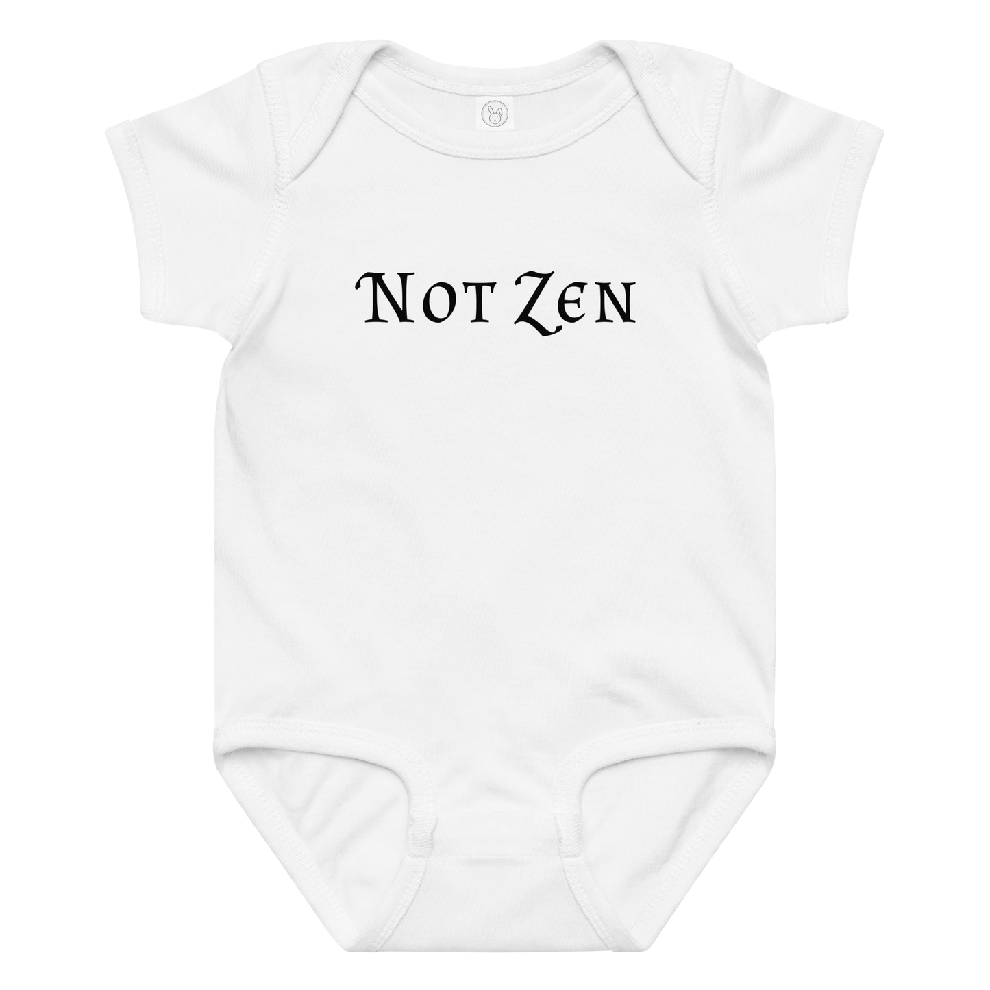 "Not zen" printed on a white baby jersey bodysuit laying on a flat surface amongst other clothes
