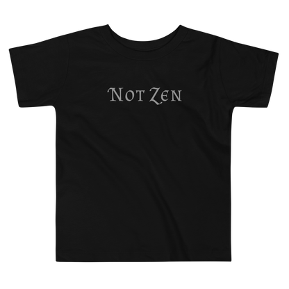 "Not zen" printed on a black toddler short sleeve tee laying on a flat surface