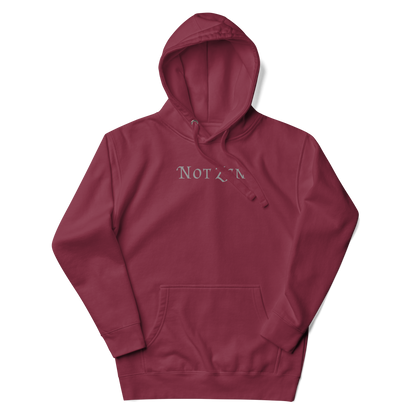 "Not zen" printed on a maroon unisex hoodie laying on a flat surface with the hood up