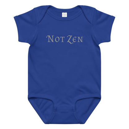 "Not zen" printed on a royal baby jersey bodysuit laying on a flat surface amongst other clothes