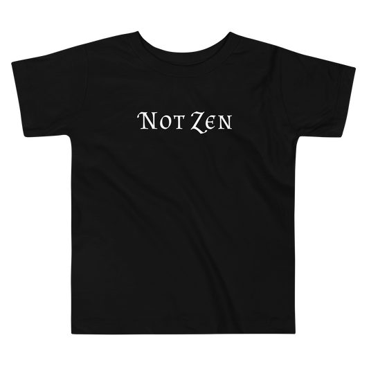 "Not zen" printed on a black toddler short sleeve tee laying on a flat surface