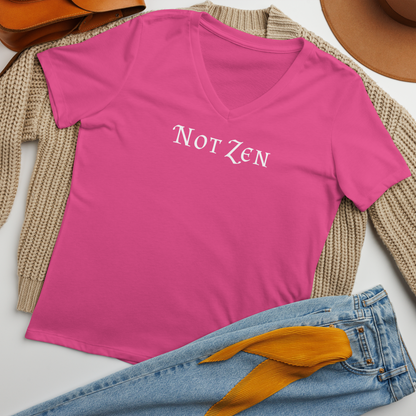 "Not zen" printed on a berry women's relaxed v-neck t-shirt laying on a flat surface amongst other clothes