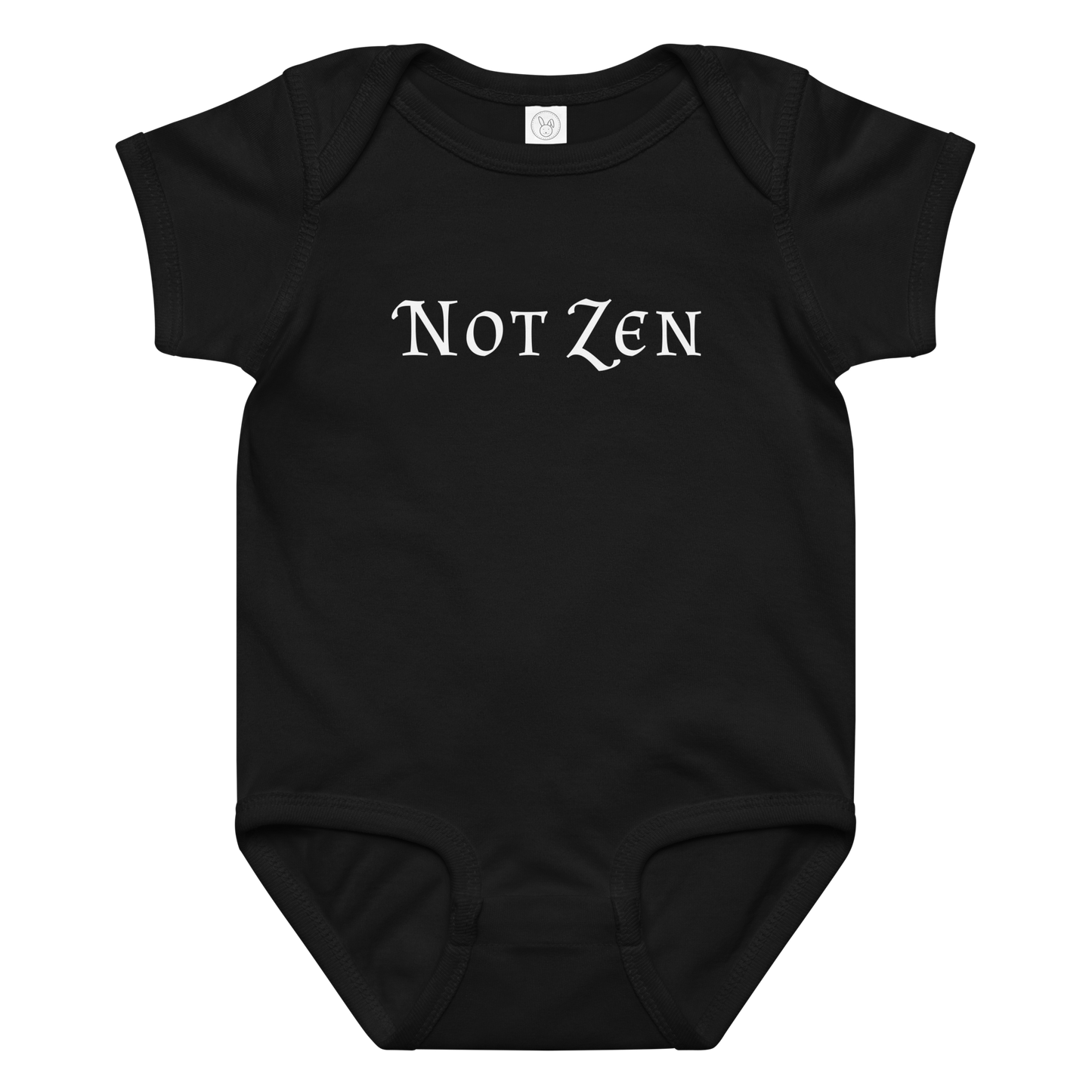 "Not zen" printed on a black baby jersey bodysuit laying on a flat surface amongst other clothes