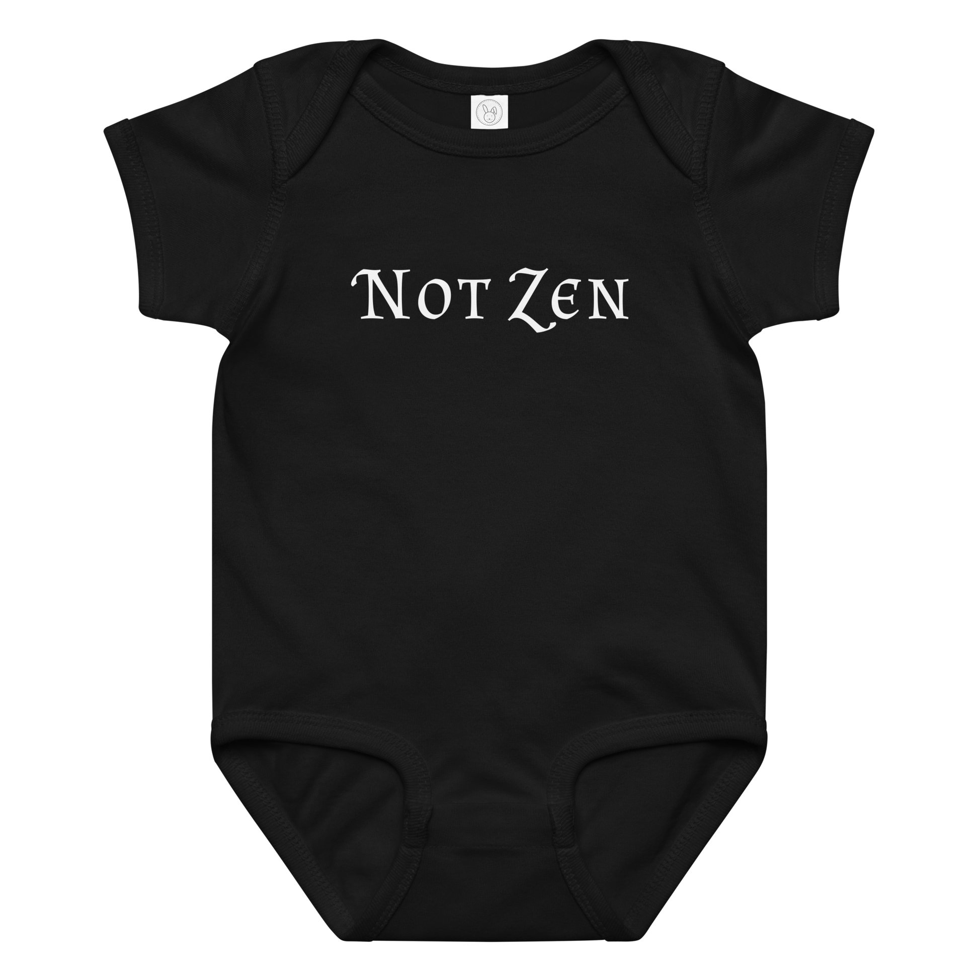 "Not zen" printed on a black baby jersey bodysuit laying on a flat surface amongst other clothes