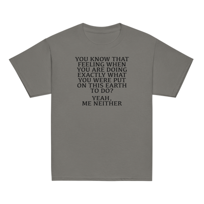 "You know that feeling when you are doing exactly what you were put on this earth to do? Yeah, Me Neither" printed on a charcoal youth classic tee laying on a flat surface