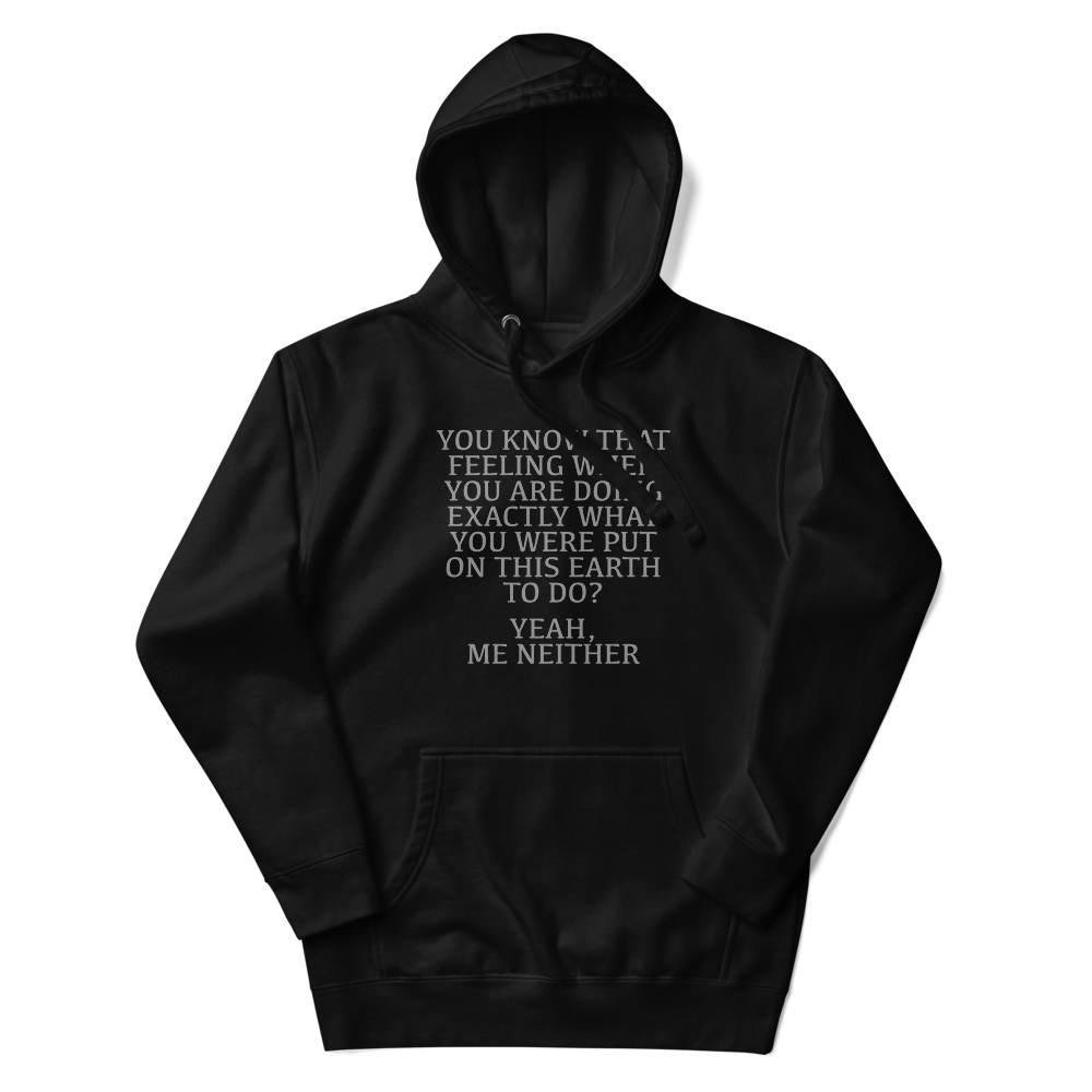 "You know that feeling when you are doing exactly what you were put on this earth to do? Yeah, Me Neither" printed on a black unisex hoodie laying on a flat surface with the hood up