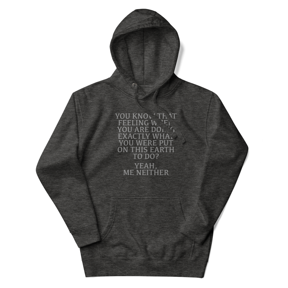 "You know that feeling when you are doing exactly what you were put on this earth to do? Yeah, Me Neither" printed on a charcoal heather unisex hoodie laying on a flat surface with the hood up