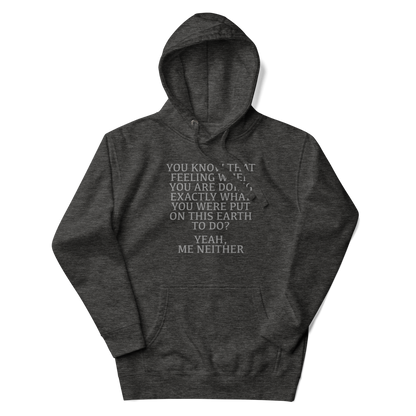 "You know that feeling when you are doing exactly what you were put on this earth to do? Yeah, Me Neither" printed on a charcoal heather unisex hoodie laying on a flat surface with the hood up