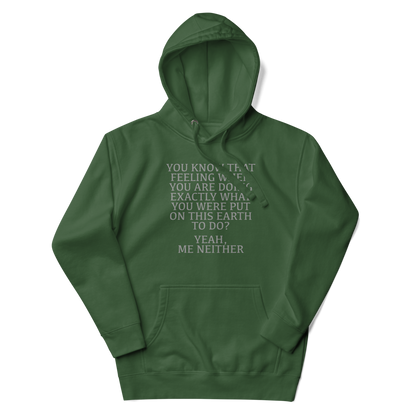 "You know that feeling when you are doing exactly what you were put on this earth to do? Yeah, Me Neither" printed on a forest green unisex hoodie laying on a flat surface with the hood up