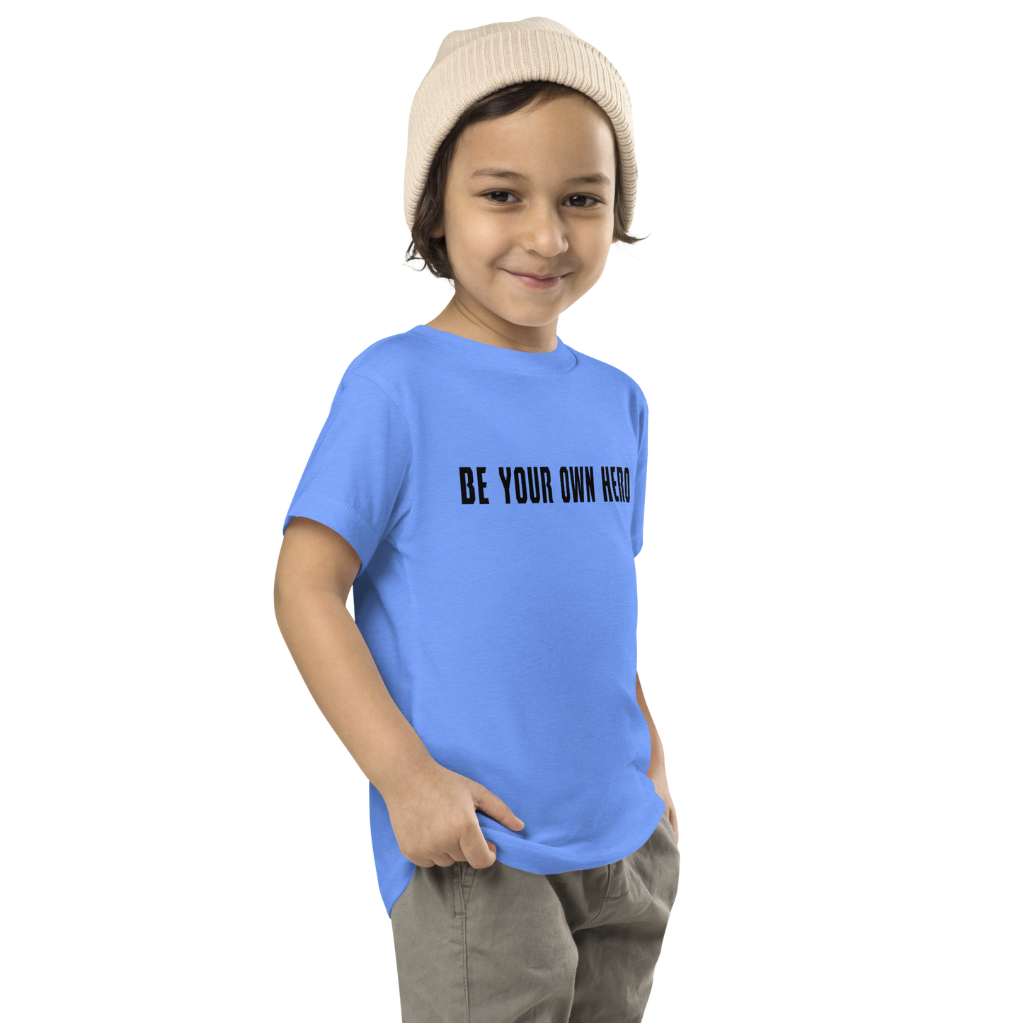 "Be your own here" printed on a heather columbia blue toddler short sleeve tee worn by a male who is also wearing a knit cap
