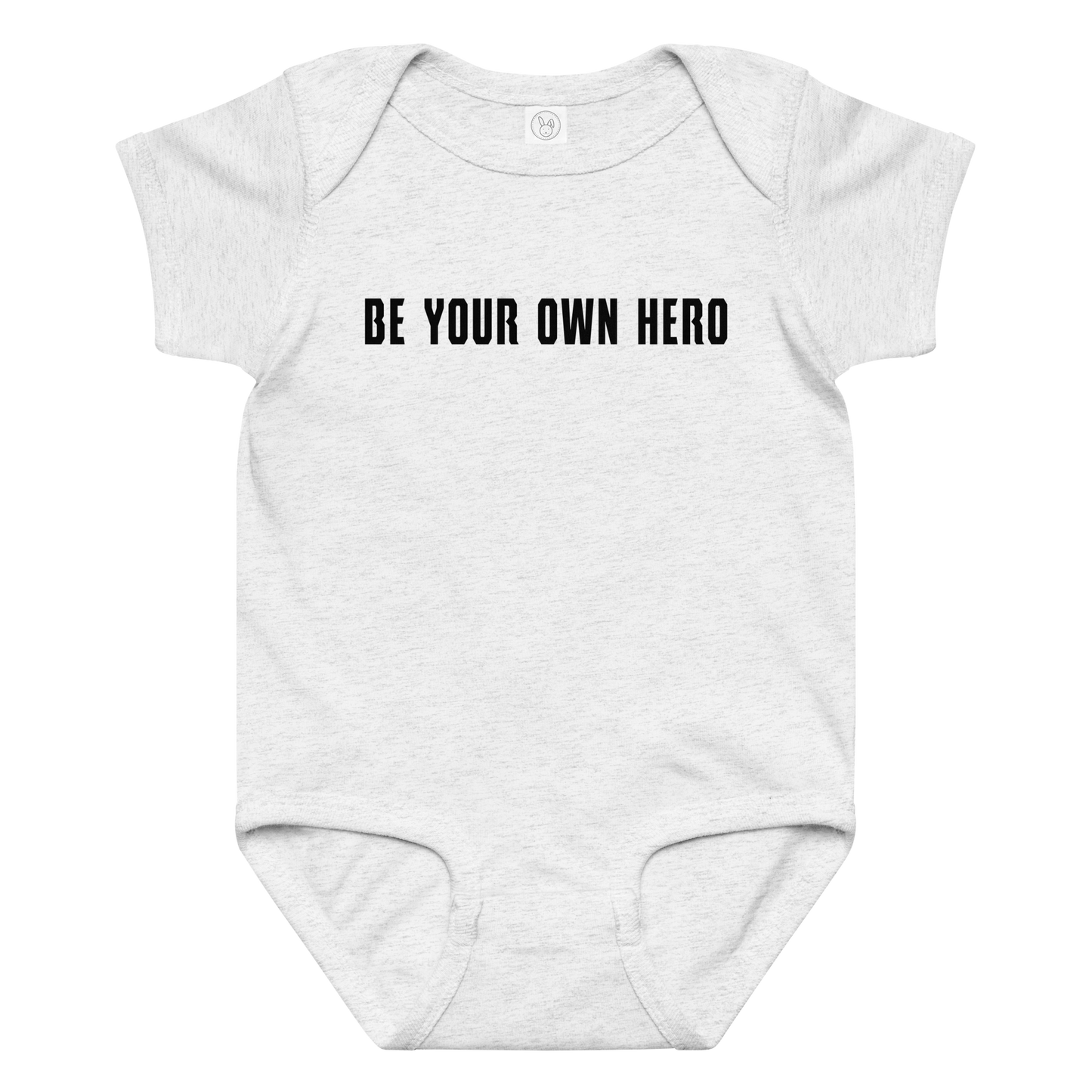 "Be your own here" printed on a ash baby jersey bodysuit laying on a flat surface amongst other clothes