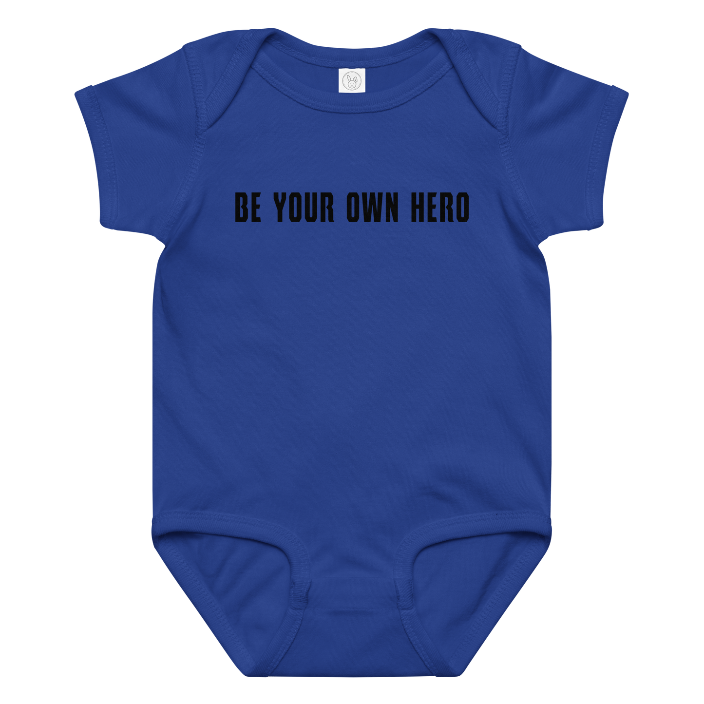 "Be your own here" printed on a royal baby jersey bodysuit laying on a flat surface amongst other clothes
