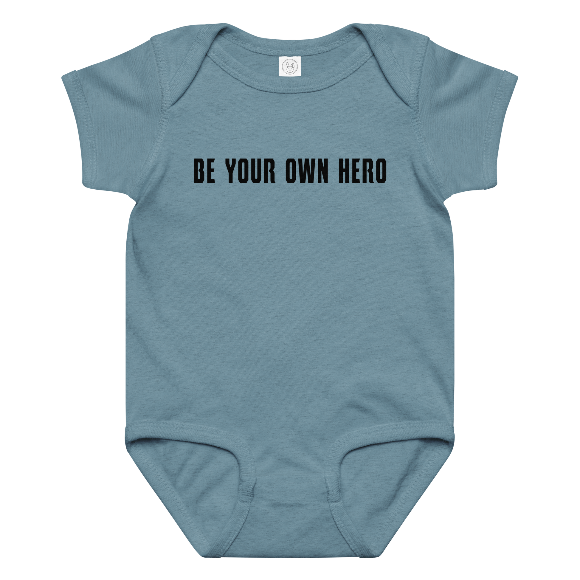 "Be your own here" printed on a vintage indigo baby jersey bodysuit laying on a flat surface amongst other clothes