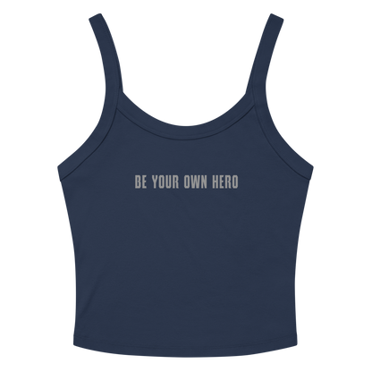 "Be your own here" printed on a solid navy blend women's micro-rib tanktop laying on a flat surface amongst sunglasses and shorts