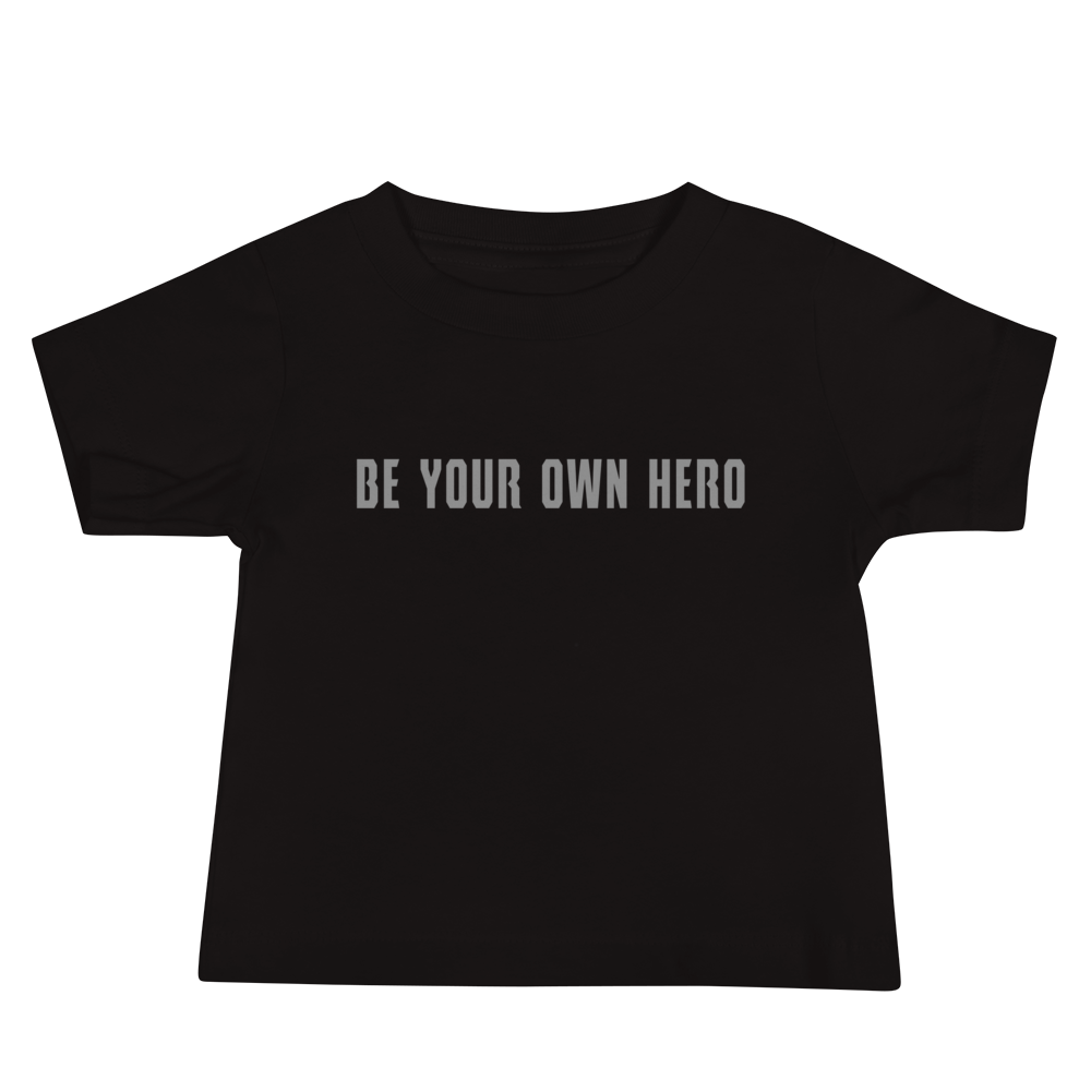 "Be your own here" printed on a black baby jersey short sleeve tee laying on a flat surface
