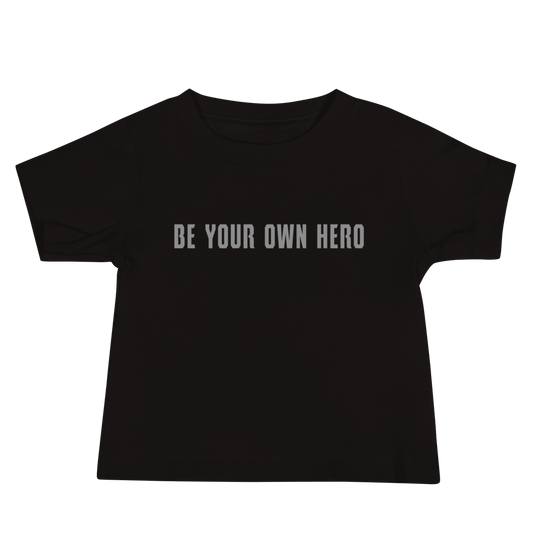 "Be your own here" printed on a black baby jersey short sleeve tee laying on a flat surface