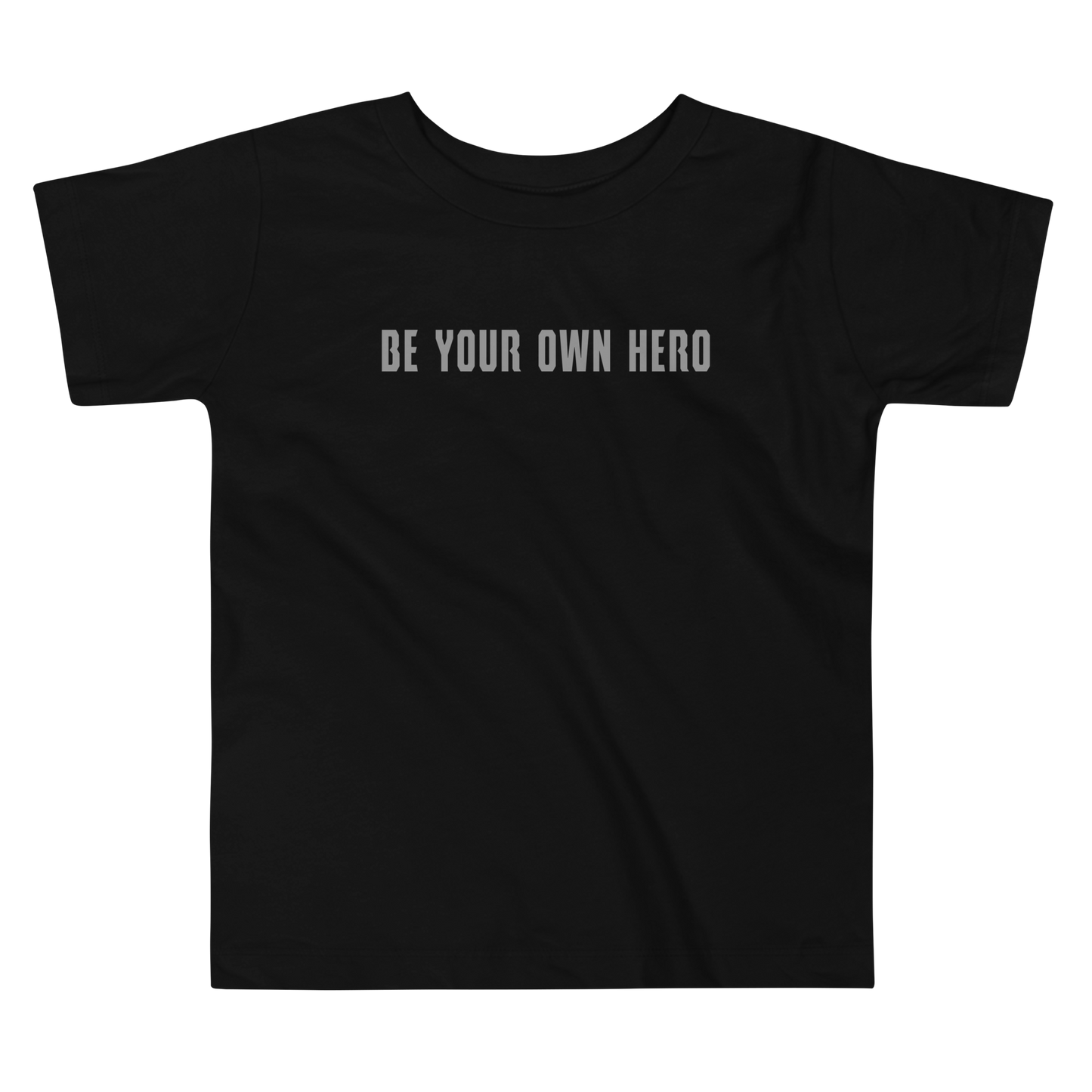 "Be your own here" printed on a black toddler short sleeve tee laying on a flat surface