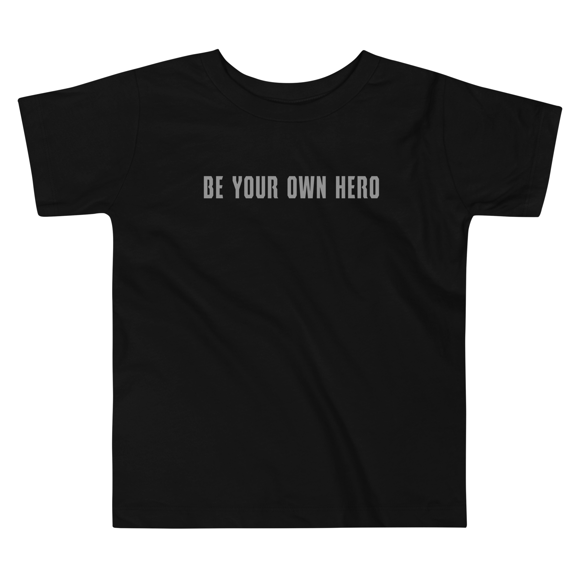 "Be your own here" printed on a black toddler short sleeve tee laying on a flat surface