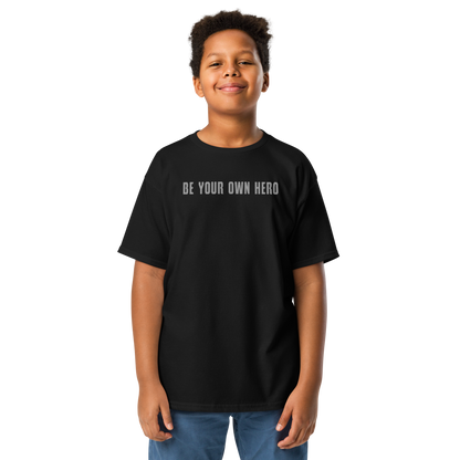 "Be your own here" printed on a black youth classic tee worn by a male